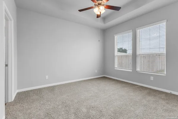a view of an empty room and chandelier fan