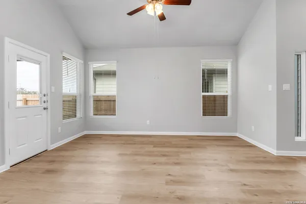 an empty room with window and a ceiling fan