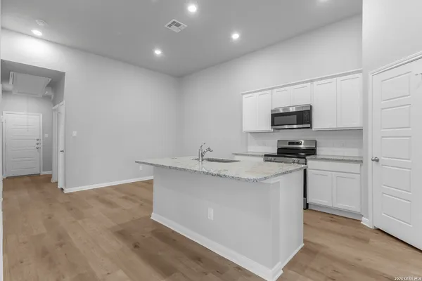 a kitchen with stainless steel appliances a sink stove refrigerator and cabinets
