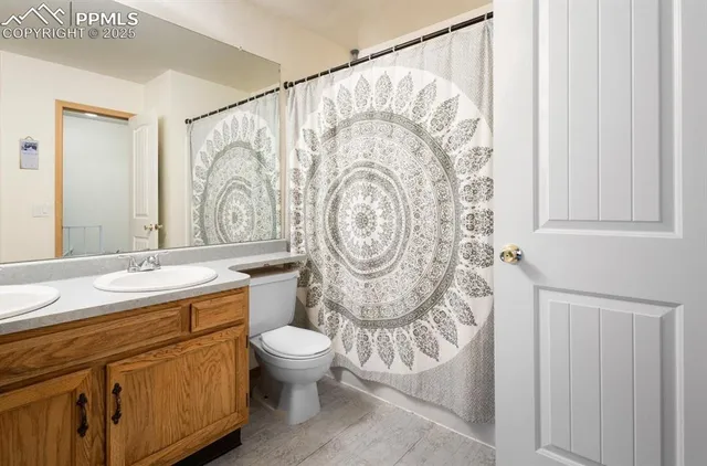 a bathroom with a toilet a sink and a shower curtain