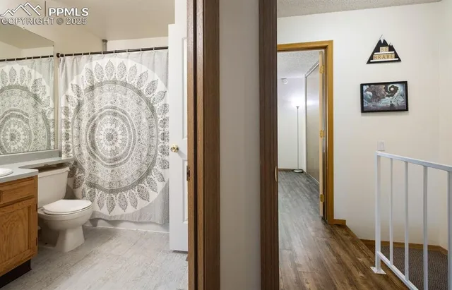 a bathroom with a toilet and a shower curtain