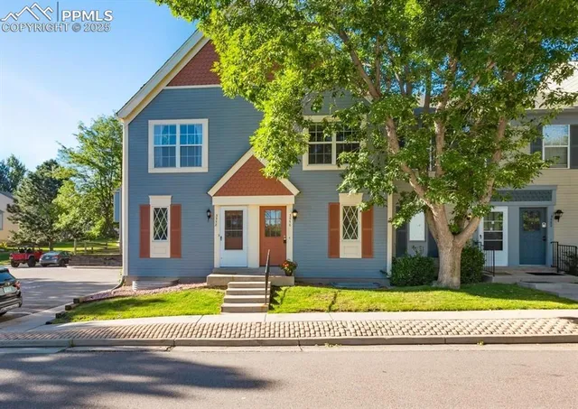 a front view of a house with a yard and trees
