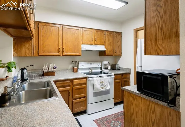 a kitchen with stainless steel appliances granite countertop a stove a sink and a microwave