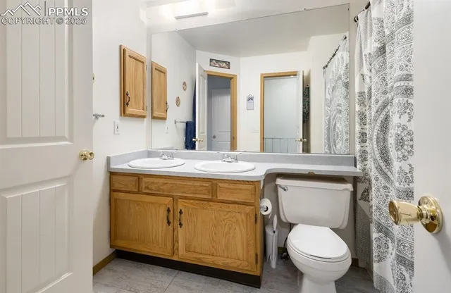 a bathroom with a granite countertop toilet sink and mirror