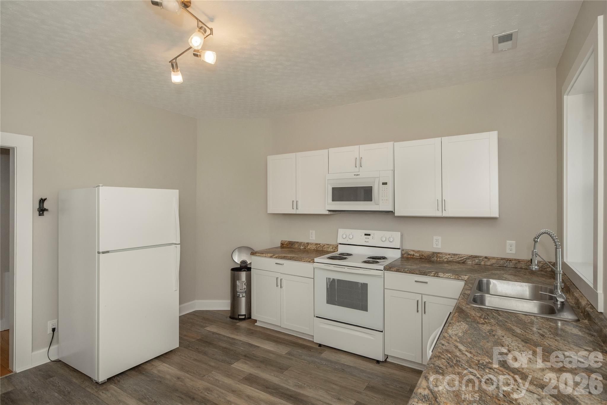 a kitchen with a white cabinets and white appliances