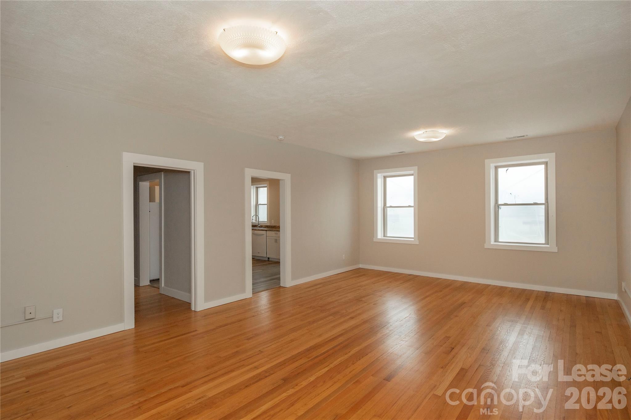 212 South Broad Street Brevard, NC 28712 - Photo 4 of 12 an empty room with wooden floor and windows