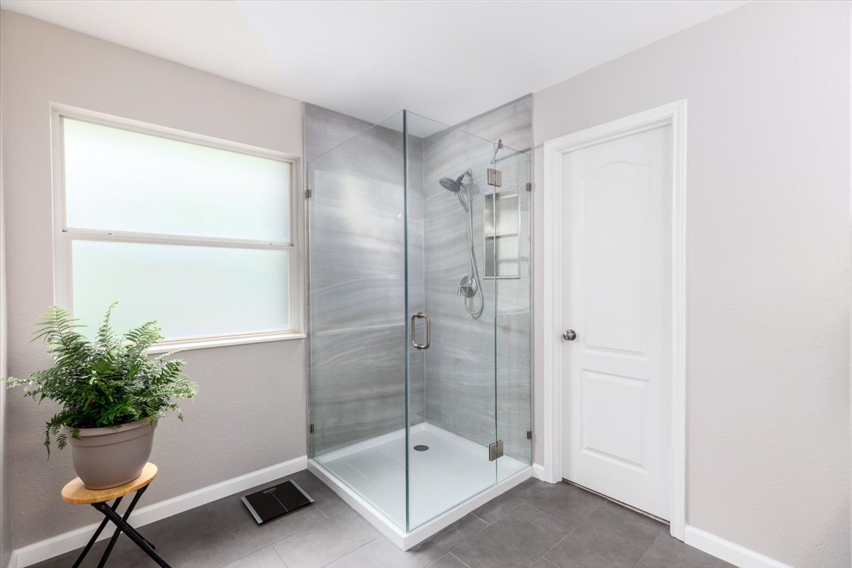 7136 Ridge Oak Road Austin, TX 78749 - Photo 20 of 28 A modern glass-enclosed shower highlights this bathroom's clean lines and contemporary design.