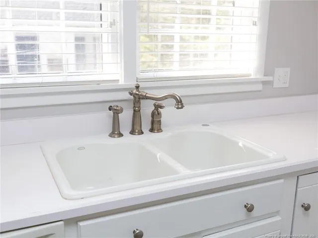 a kitchen with granite countertop white cabinets and a stove