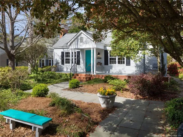 a front view of a house with a yard and a garden