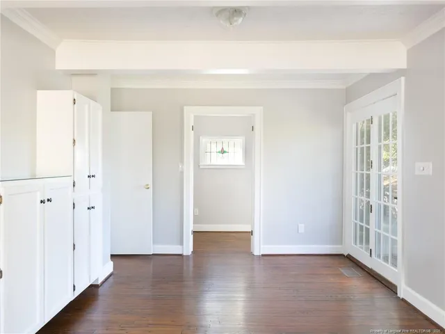 an empty room with wooden floor and window