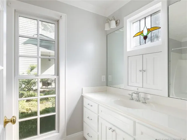 a bathroom with a granite countertop sink a mirror and a window