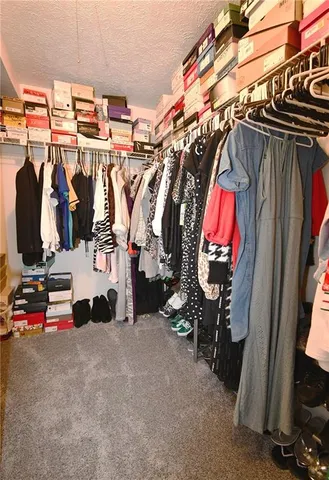 a view of walk in closet with clothes