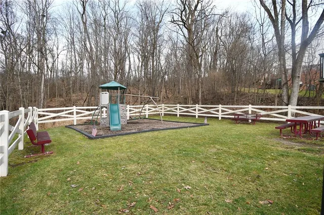a view of swimming pool with lawn chairs and wooden fence