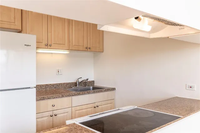 a kitchen with granite countertop white cabinets and a sink