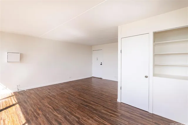 a view of empty room with wooden floor