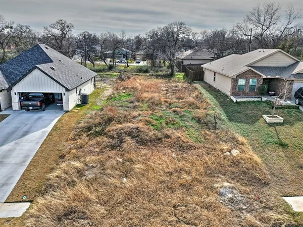 an aerial view of a house with a yard and large trees