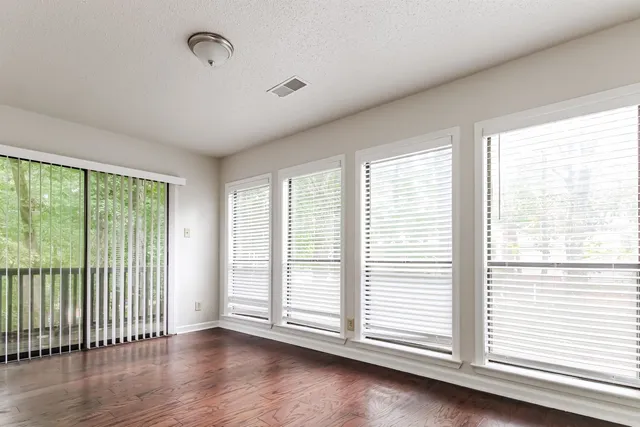 a view of an empty room with wooden floor