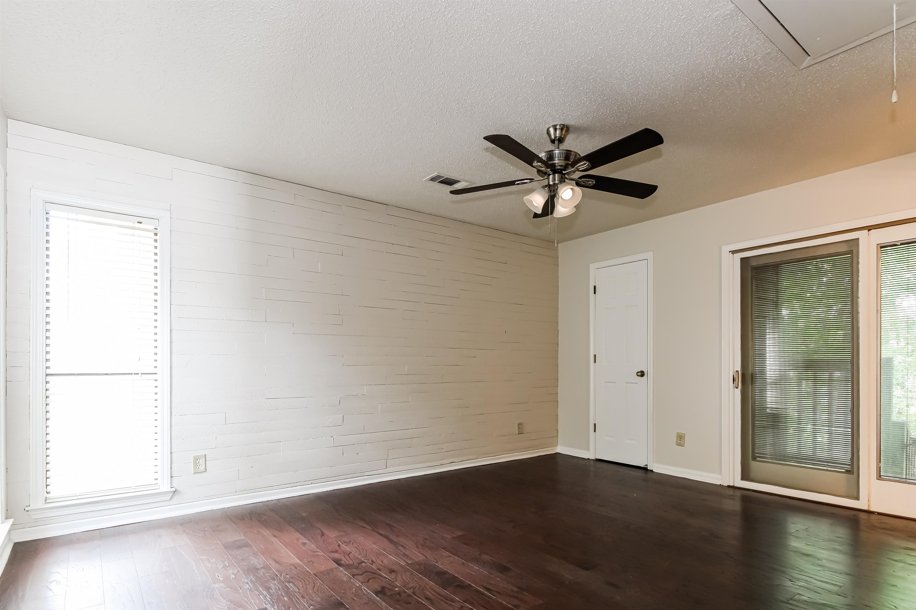 8661 Roundtree Place Memphis, TN 38016 - Photo 8 of 17 an empty room with wooden floor and ceiling fan