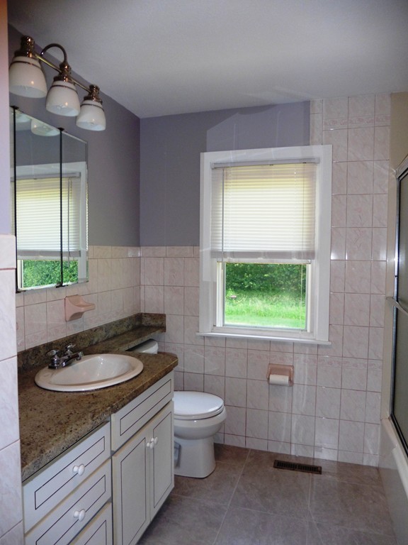 131 Sunbrier Road Springfield, MA 01129 - Photo 9 of 22 a bathroom with a granite countertop sink toilet a mirror and window