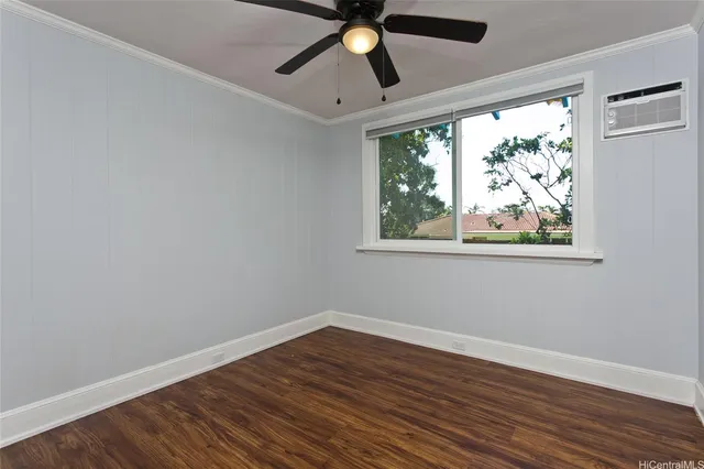 a view of empty room with wooden floor and fan