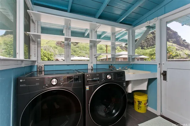 a utility room with dryer washer and a large window