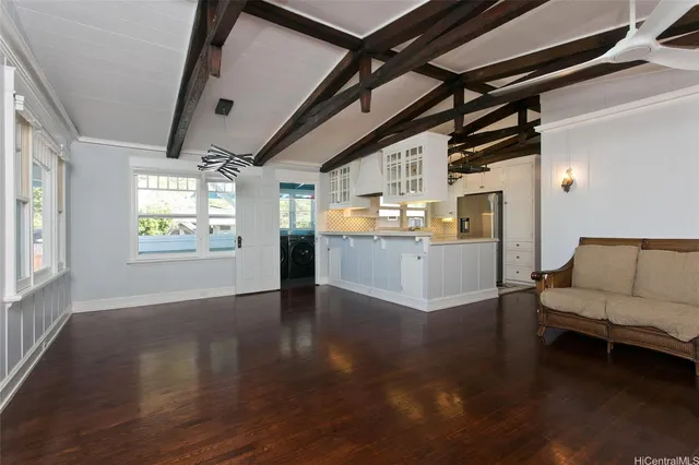 a view of a livingroom with wooden floor and a kitchen