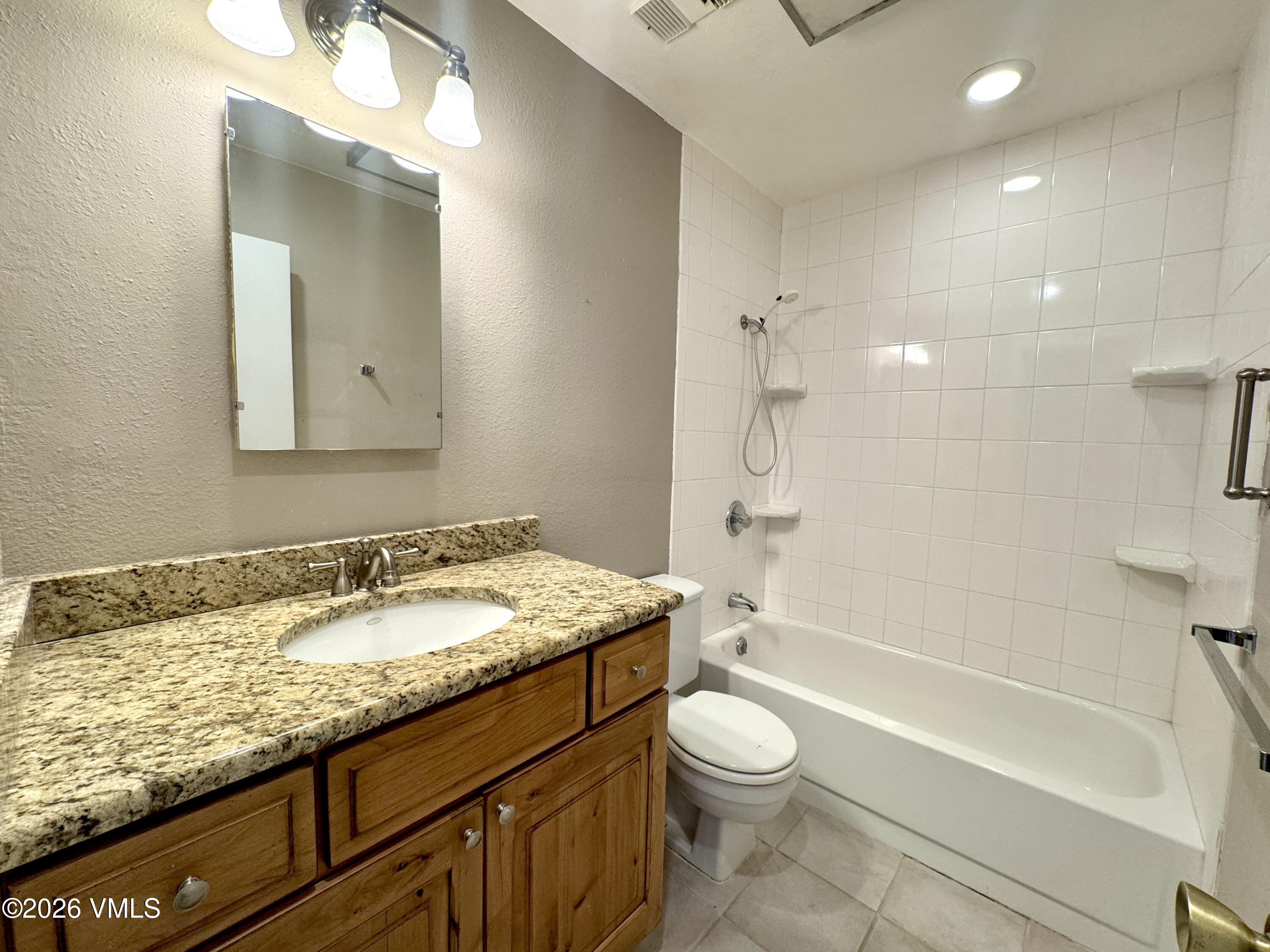3921 Big Horn Road, Unit 3B Vail, CO 81657 - Photo 16 of 16 a bathroom with a granite countertop sink a toilet and bathtub