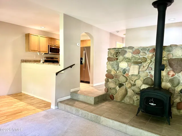 a living room with a fireplace and a floor to ceiling window
