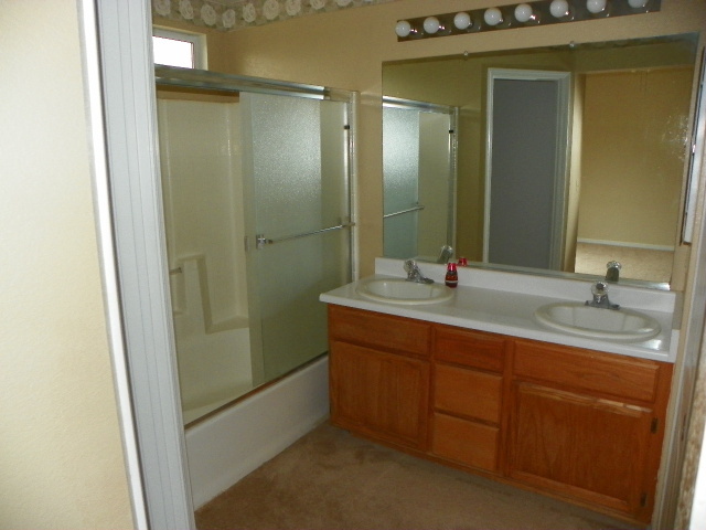 710 Mallard Street Redding, CA 96003 - Photo 13 of 19 a bathroom with a double vanity sink and mirror