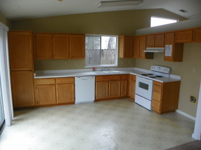 710 Mallard Street Redding, CA 96003 - Photo 6 of 19 a kitchen with stainless steel appliances granite countertop a stove a sink and a refrigerator