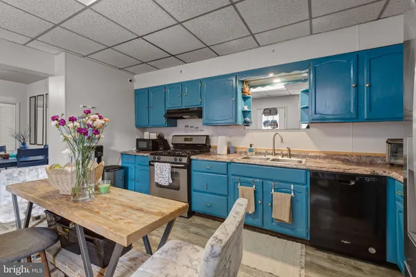 a kitchen with kitchen island granite countertop a sink cabinets and wooden floor