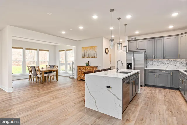 a kitchen with stainless steel appliances kitchen island granite countertop a refrigerator and a stove top oven