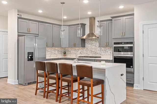 a large kitchen with kitchen island a sink table and chairs