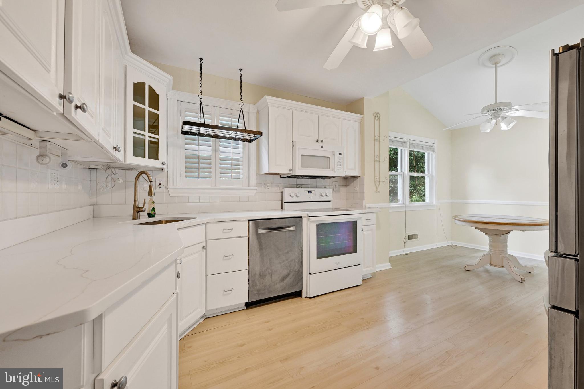 809 Providence Road Towson, MD 21286 - Photo 9 of 26 a kitchen with stainless steel appliances a stove a sink dishwasher a refrigerator and white cabinets with wooden floor