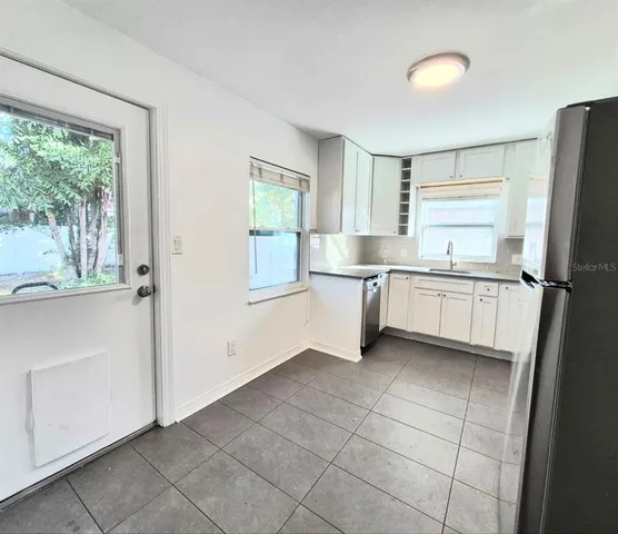 a kitchen with white cabinets and white appliances