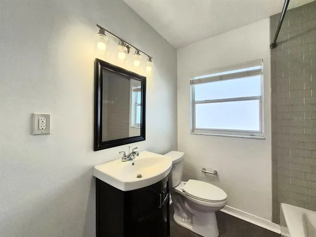 a bathroom with a sink toilet and mirror