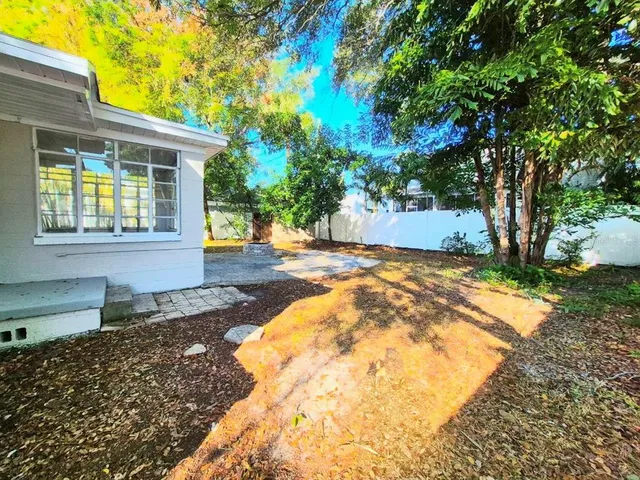 a view of a backyard with a garden and tree