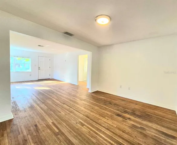 a view of an empty room and wooden floor