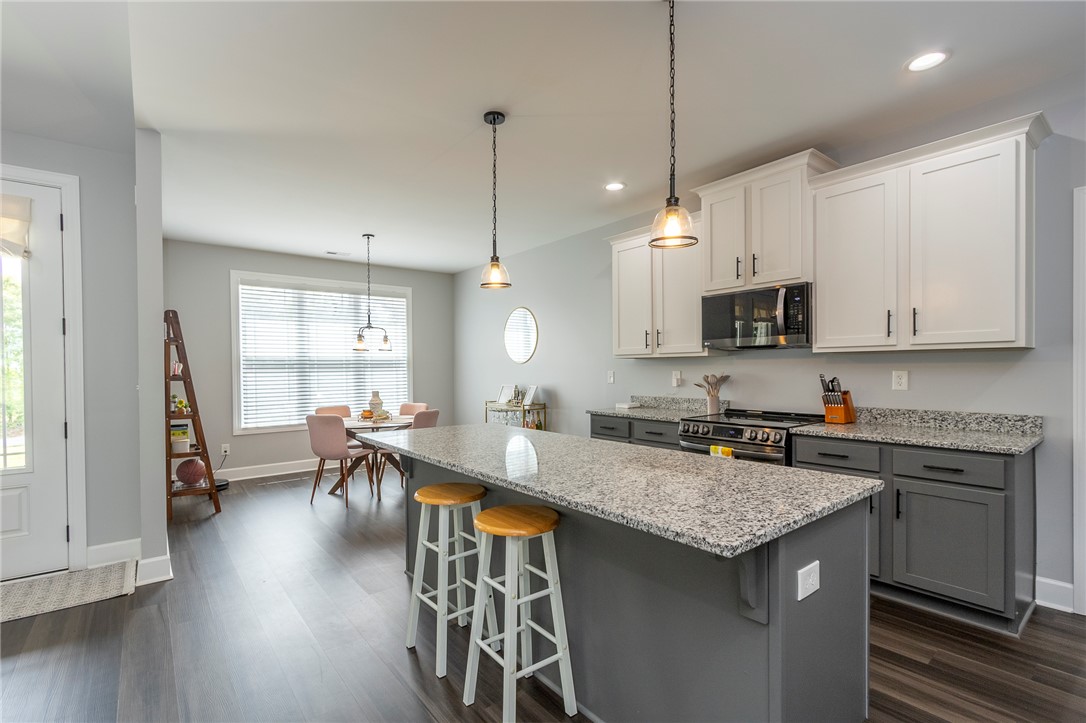 3080 McGee Road Iva, SC 29655 - Photo 10 of 49 A well-lit kitchen with granite countertops, an island, and sleek appliances.
