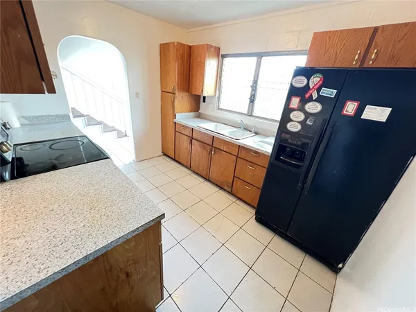 a kitchen with stainless steel appliances kitchen island granite countertop a refrigerator a stove a sink and dishwasher