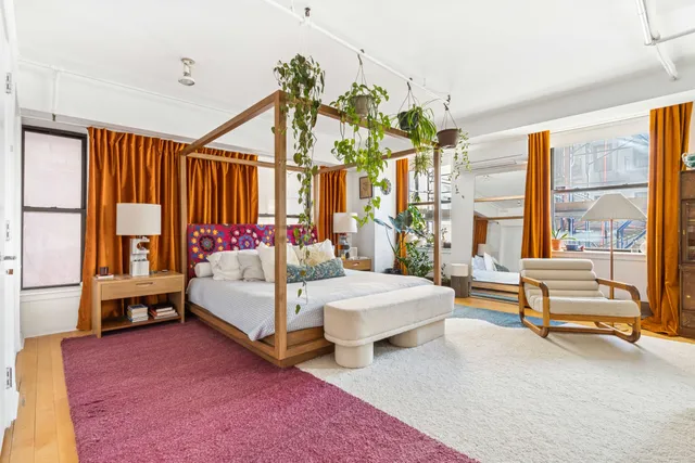 a bedroom with a bed and large windows