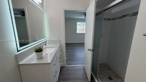 a bathroom with a sink a mirror and shower