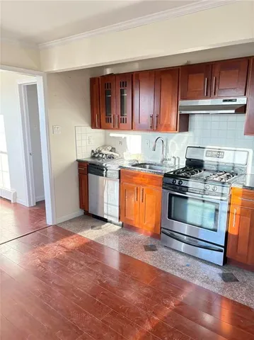 a kitchen with granite countertop stainless steel appliances and wooden cabinets