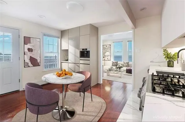 a living room with furniture and a dining table with wooden floor