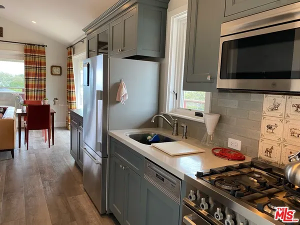 a kitchen with stainless steel appliances a stove a sink and a microwave