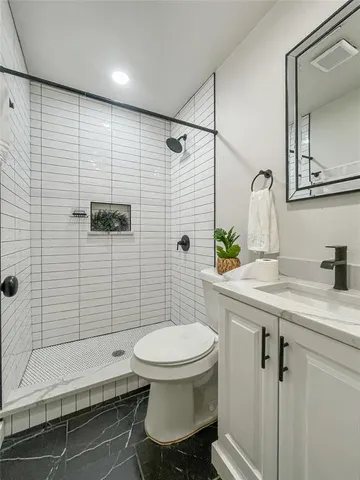 a bathroom with a sink a toilet and shower