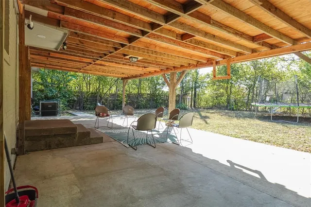 a view of a patio with a table and chairs under a large umbrella