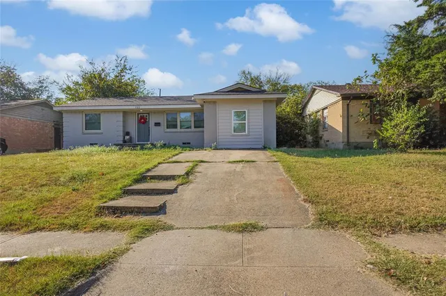 a view of a house with a yard and potted plants