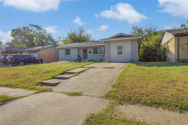 a view of a house with a yard and potted plants