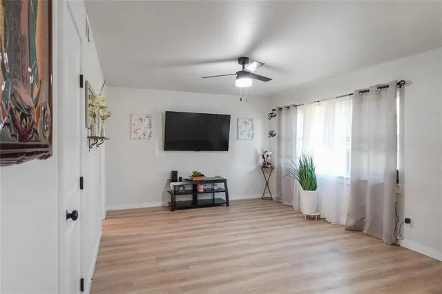 a view of a livingroom with wooden floor and a flat screen tv